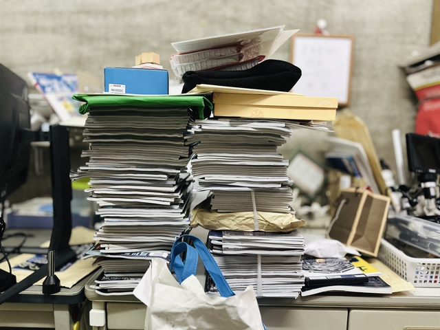 書類が積み重なって山になっているイメージ